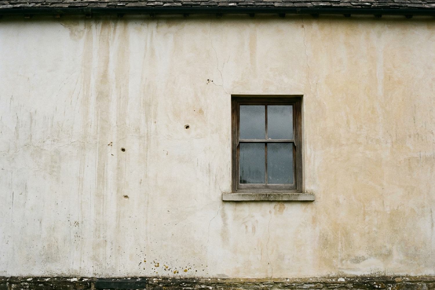 A plain wall of weathered render in even light.